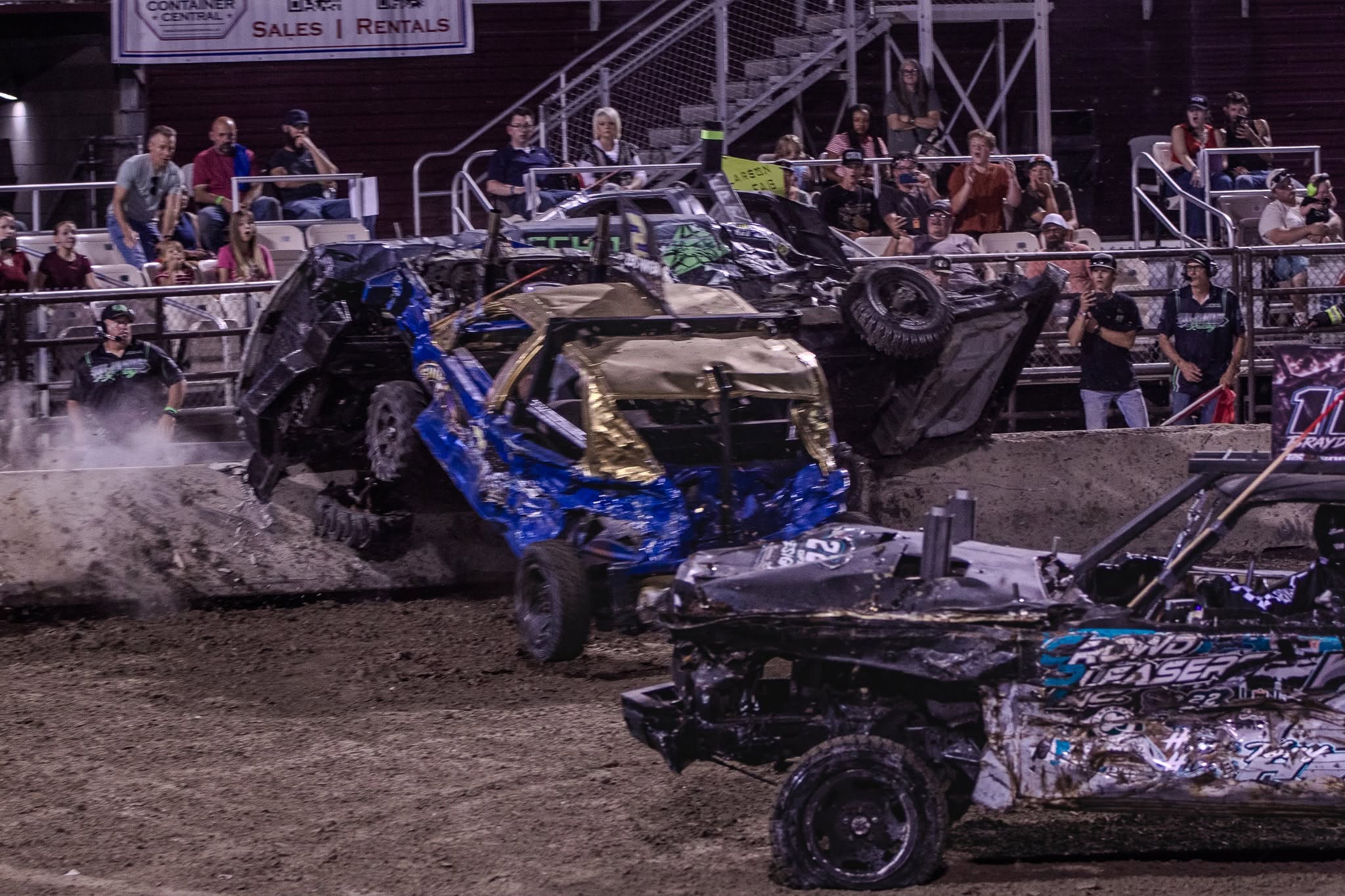 Demolition derby competitors battling in a dirt arena