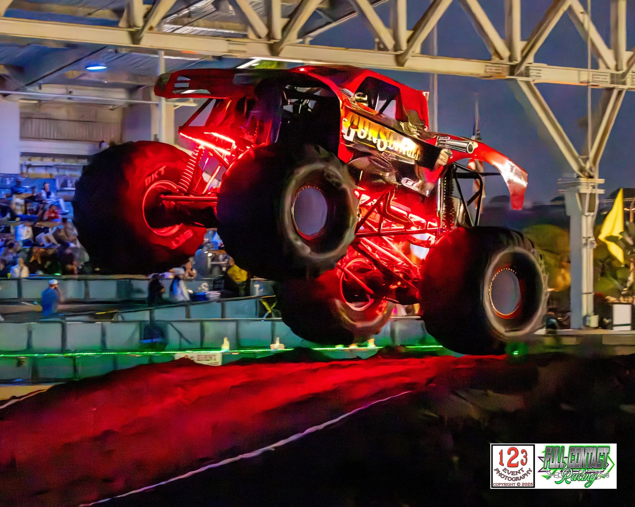 Monster truck airborne in an arena during a live event